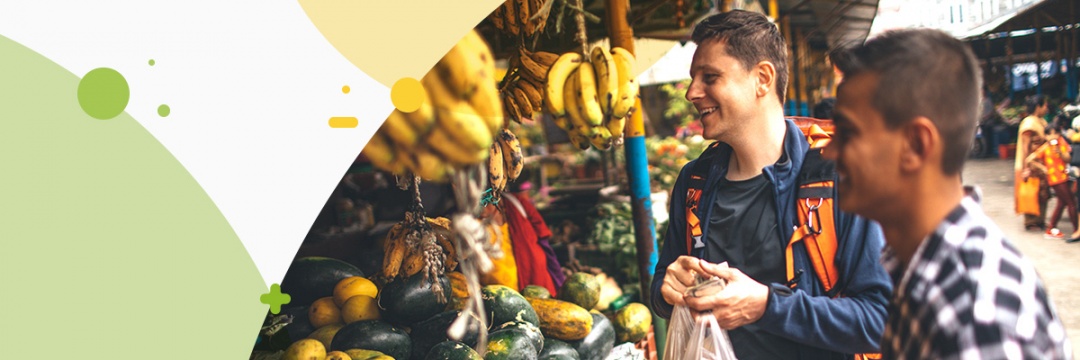 2 young guys buying fruit at an asian food stand
