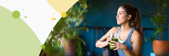 Young women holding a jar with green smoothie