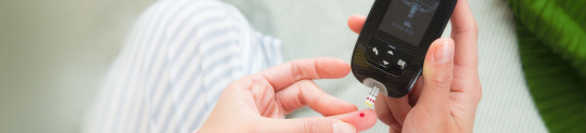 Maria measuring her blood sugar with an Accu-Chek blood glucose meter