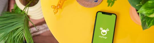 Table with phone and mySugr App